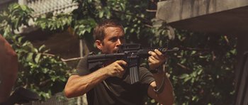 Movie still from “Fast Five” (2011), directed by Justin Lin – A man holding an ar - 1 5 style rifle in his hands; Close Up shot, Over the shoulder angle