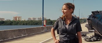 Movie still from “Fast Five” (2011), directed by Justin Lin – A woman in a police uniform standing on the side of a road; Medium shot, Over the shoulder angle