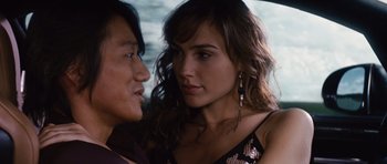 Movie still from “Fast Five” (2011), directed by Justin Lin – A woman and a young man standing next to each other in a car; Close Up shot, Over the shoulder angle