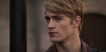 Movie still from “Fate: The Winx Saga” (2021), created by Brian Young – A person wearing a brown shirt; Close Up shot, Over the shoulder angle