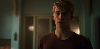 Movie still from “Fate: The Winx Saga” (2021), created by Brian Young – A young man with blonde hair and a brown shirt; Close Up shot, Over the shoulder angle