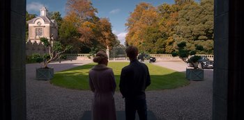 Movie still from “Fate: The Winx Saga” (2021), created by Brian Young – A man and a woman standing in front of trees; Wide shot, High angle