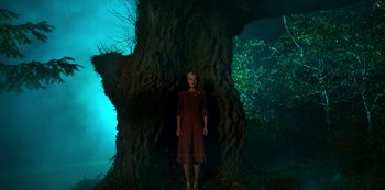 Movie still from “Fate: The Winx Saga” (2021), created by Brian Young – A woman standing in front of a large tree; Wide shot, Low angle
