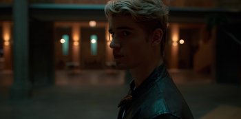 Movie still from “Fate: The Winx Saga” (2021), created by Brian Young – A man with blonde hair wearing a leather jacket; Close Up shot, Over the shoulder angle