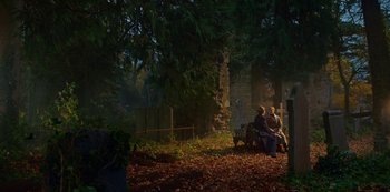 Movie still from “Fate: The Winx Saga” (2021), created by Brian Young – Two people sitting on a bench in the woods; Extreme Wide shot, High angle