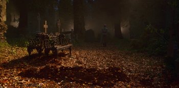 Movie still from “Fate: The Winx Saga” (2021), created by Brian Young – A person standing on the ground near a bench; Extreme Wide shot, High angle