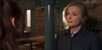 Movie still from “Fate: The Winx Saga” (2021), created by Brian Young – A woman standing in front of a pillar in a room; Close Up shot, Over the shoulder angle