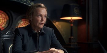 Movie still from “Fate: The Winx Saga” (2021), created by Brian Young – A woman sitting in front of a lamp in a dark room; Close Up shot, Over the shoulder angle