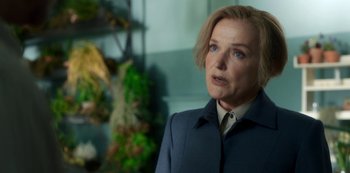 Movie still from “Fate: The Winx Saga” (2021), created by Brian Young – A woman with blonde hair wearing a blue coat; Close Up shot, Over the shoulder angle