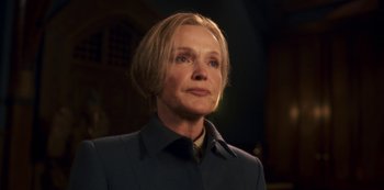 Movie still from “Fate: The Winx Saga” (2021), created by Brian Young – A woman with blonde hair wearing a blue jacket; Close Up shot, Low angle