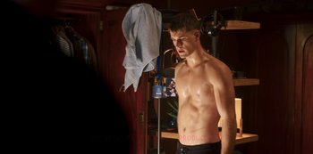 Movie still from “Fate: The Winx Saga” (2021), created by Brian Young – A shirtless man in front of a mirror in a room; Medium shot, Low angle
