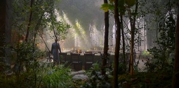 Movie still from “Fate: The Winx Saga” (2021), created by Brian Young – A man standing in front of a table in the middle of a forest; Wide shot, High angle