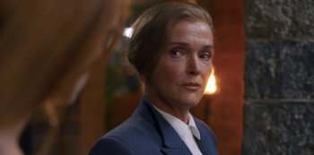 Movie still from “Fate: The Winx Saga” (2021), created by Brian Young – A person wearing a suit and tie; Close Up shot, Over the shoulder angle