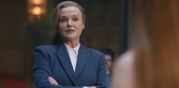 Movie still from “Fate: The Winx Saga” (2021), created by Brian Young – A woman in a blue suit with her arms crossed; Close Up shot, Over the shoulder angle