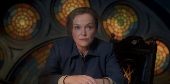 Movie still from “Fate: The Winx Saga” (2021), created by Brian Young – A woman sitting in front of a stained glass window; Close Up shot, Low angle