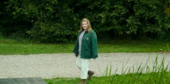 Movie still from “Fate: The Winx Saga” (2021), created by Brian Young – A woman walking down the street in a green jacket; Wide shot, High angle