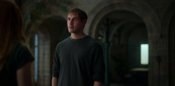 Movie still from “Fate: The Winx Saga” (2021), created by Brian Young – A man standing in a dark room looking up at the sky; Medium shot, Over the shoulder angle