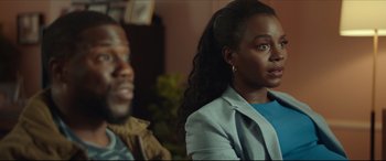 Movie still from “Fatherhood” (2021), directed by Paul Weitz – A woman sitting next to a man in a room; Close Up shot, Over the shoulder angle