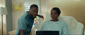 Movie still from “Fatherhood” (2021), directed by Paul Weitz – A man and a woman looking at a laptop in a hospital room; Medium shot, Over the shoulder angle