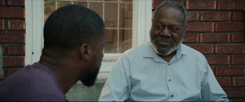 Movie still from “Fatherhood” (2021), directed by Paul Weitz – Two men are sitting outside talking to each other; Close Up shot, Over the shoulder angle