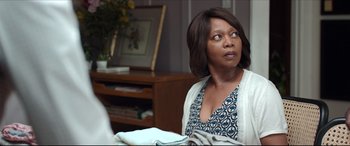 Movie still from “Fatherhood” (2021), directed by Paul Weitz – A woman sitting in a living room looking up at the ceiling; Medium shot, Over the shoulder angle
