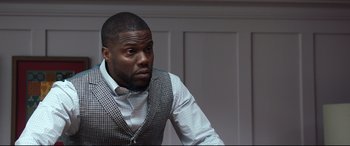 Movie still from “Fatherhood” (2021), directed by Paul Weitz – A person sitting in a chair wearing a vest; Close Up shot, Over the shoulder angle