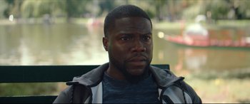 Movie still from “Fatherhood” (2021), directed by Paul Weitz – A person sitting on a bench; Close Up shot, Over the shoulder angle