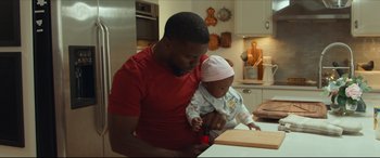 Movie still from “Fatherhood” (2021), directed by Paul Weitz – A man and a baby in a kitchen; Medium shot, Over the shoulder angle