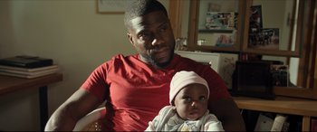 Movie still from “Fatherhood” (2021), directed by Paul Weitz – A man holding a baby in his arms; Close Up shot, Over the shoulder angle