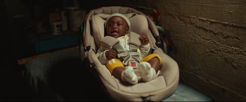 Movie still from “Fatherhood” (2021), directed by Paul Weitz – A baby in a car seat with a hat on; Close Up shot, High angle