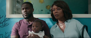 Movie still from “Fatherhood” (2021), directed by Paul Weitz – A man and a woman holding a baby in a room; Medium shot, Over the shoulder angle