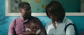 Movie still from “Fatherhood” (2021), directed by Paul Weitz – A man and a woman holding a baby in a room; Close Up shot, Over the shoulder angle