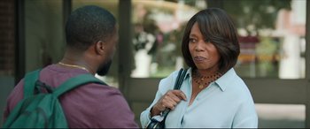 Movie still from “Fatherhood” (2021), directed by Paul Weitz – An older black woman holding a black cane talking to a younger black man; Medium shot, Over the shoulder angle