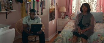 Movie still from “Fatherhood” (2021), directed by Paul Weitz – A man sitting on a chair in a bedroom; Medium shot, Over the shoulder angle