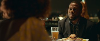 Movie still from “Fatherhood” (2021), directed by Paul Weitz – A man sitting at a table with a glass of orange juice; Close Up shot, Over the shoulder angle