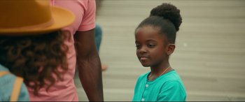 Movie still from “Fatherhood” (2021), directed by Paul Weitz – A little girl sitting next to an older man; Close Up shot, Over the shoulder angle