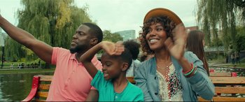 Movie still from “Fatherhood” (2021), directed by Paul Weitz – A group of people sitting next to each other on a field; Medium shot, Over the shoulder angle