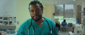 Movie still from “Fatherhood” (2021), directed by Paul Weitz – A man with a stethoscope around his neck; Close Up shot, Low angle