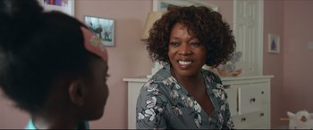 Movie still from “Fatherhood” (2021), directed by Paul Weitz – A person with curly hair smiling; Close Up shot, Over the shoulder angle