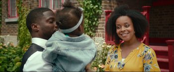 Movie still from “Fatherhood” (2021), directed by Paul Weitz – A woman holding a baby in her arms and smiling; Close Up shot, Over the shoulder angle