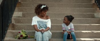 Movie still from “Fatherhood” (2021), directed by Paul Weitz – A woman and a child sitting on a set of steps; Medium shot, Over the shoulder angle