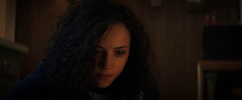 Movie still from “Fear Street: Part Two - 1978” (2021), directed by Leigh Janiak – A person with long black curly hair; Close Up shot, High angle