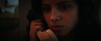 Movie still from “Fear Street: Part Two - 1978” (2021), directed by Leigh Janiak – A woman is talking on a phone while looking at the camera; Close Up shot, Low angle