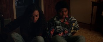 Movie still from “Fear Street: Part Two - 1978” (2021), directed by Leigh Janiak – A woman and a man sitting on the floor; Medium shot, High angle