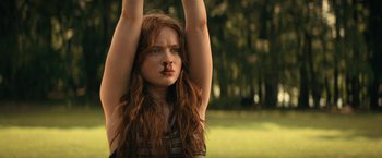 Movie still from “Fear Street: Part Two - 1978” (2021), directed by Leigh Janiak – A woman with long red hair is stretching her arms up; Medium shot, Low angle