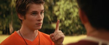 Movie still from “Fear Street: Part Two - 1978” (2021), directed by Leigh Janiak – A man in an orange shirt is pointing to the side; Close Up shot, Over the shoulder angle