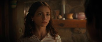 Movie still from “Fear Street: Part Two - 1978” (2021), directed by Leigh Janiak – A young woman is looking at the camera while standing in front of a fireplace; Close Up shot, Over the shoulder angle