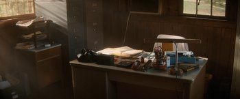 Movie still from “Fear Street: Part Two - 1978” (2021), directed by Leigh Janiak – An office desk with a lot of papers on top of it; Wide shot, High angle