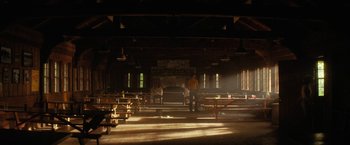 Movie still from “Fear Street: Part Two - 1978” (2021), directed by Leigh Janiak – Two people are standing in a room with benches; Extreme Wide shot, Low angle