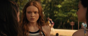 Movie still from “Fear Street: Part Two - 1978” (2021), directed by Leigh Janiak – A young woman with long red hair is looking at the camera; Close Up shot, Over the shoulder angle